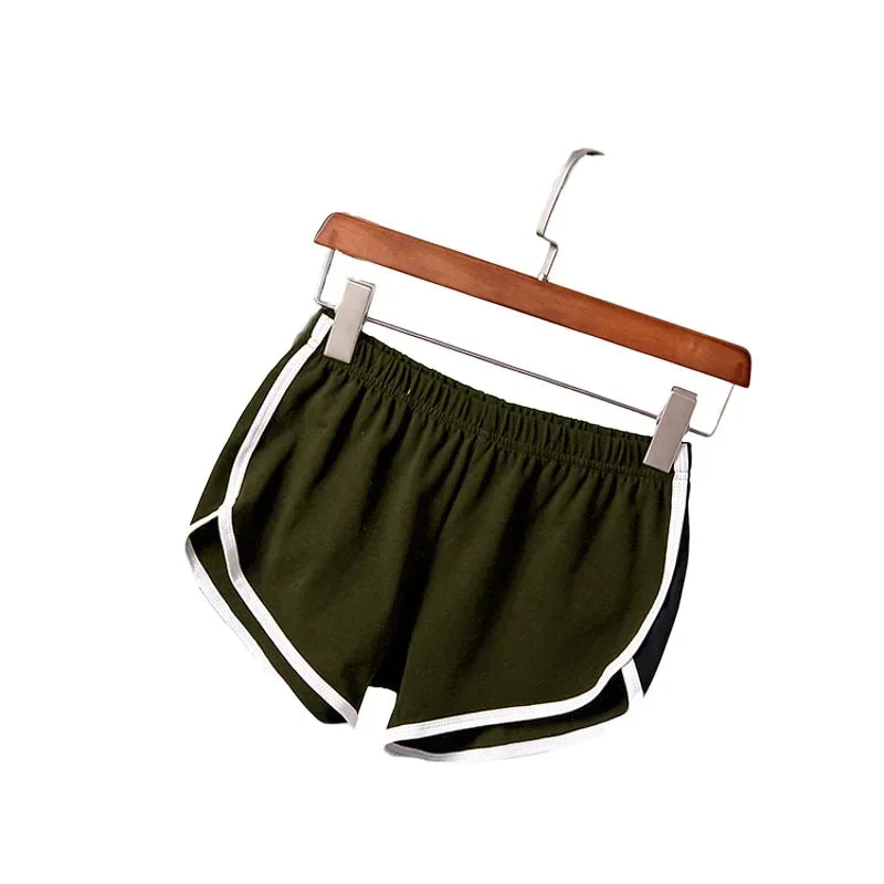 Green shorts with white trim on a wooden hanger against a white background