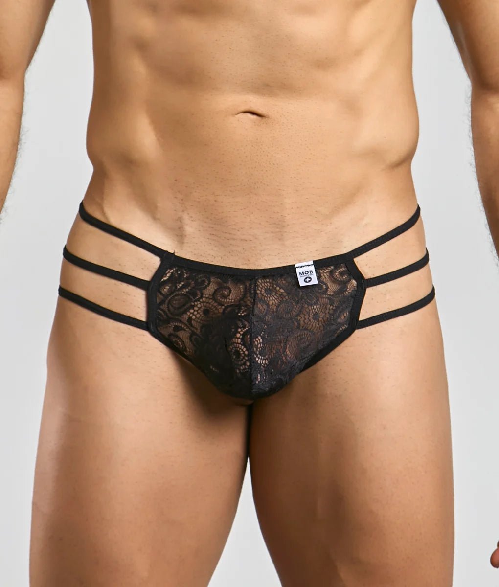 Front view of a men's black floral lace thong with three narrow straps at each hip.